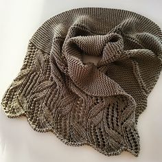 a knitted scarf laying on top of a white surface