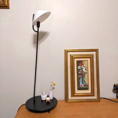 a table with a lamp and pictures on the wall