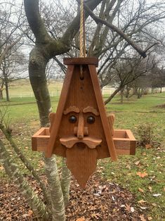 a wooden face hanging from the side of a tree