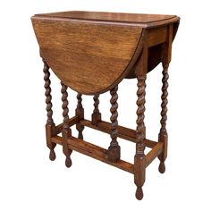 an old wooden table with turned legs and a triangular shaped shelf on one end, isolated against a white background