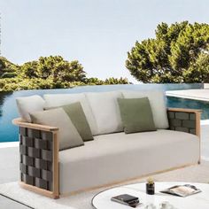 a couch sitting on top of a white table next to a pool