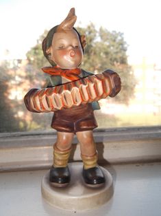 a small figurine sitting on top of a window sill