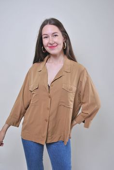 "Vintage minimalist brown blouse, retro summer shirt, Size L Welcome to TARASCOMMON.ETSY.COM Unique clothing from the 20th century.   Model tall - 170cm   Size: L. Sleeve - 30cm / 11.81inch; ( armpit to end of sleeve); Width - 56cm / 22.04inch; Length - 64cm / 25.19inch.    All measurements are taken seam to seam while lying flat.   Viscose. This item is vintage, so it can have some defects. Additional photos can be send   We are glad that you are interested in lots that we sell. Wish you a good Spring Brown Shirt With Pockets, Brown Shirts With Pockets For Spring, Brown Button-up Blouse, Brown Button-up Top With Pockets, Brown Button-up Blouse With Button Closure, Brown Lapel Collar Top For Work, Spring Brown Shirt For Workwear, Brown Shirt For Spring Workwear, Spring Brown Shirt For Work