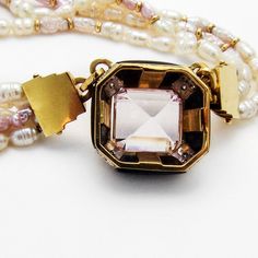 "Retro multi-strand two tone Fresh Water Pearl necklace, decorated with 14 K (.585) yellow gold chamfered square form pendant, featuring pale Amethyst centerpiece and Onyx borders, accented with Diamonds. Necklace also has yellow gold clasp and tiny bead accents. This majestic necklace is 17 7/8\" long, the pendant is 3/4\" square, the stone measures 12 mm x 13mm. EA461." Square Gemstone Jewelry For Formal Occasions, Formal Square Gemstone Jewelry, Gold Rectangular Multi-stone Jewelry, Elegant Multi-stone Rectangular Jewelry, Elegant Rectangular Multi-stone Jewelry, Square Fine Jewelry For Formal Occasions, Exquisite Rectangular Formal Jewelry, Luxury Rectangular Jewelry With Gemstone Accents, Square Yellow Gold Jewelry With Gemstone