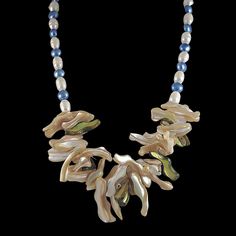 Wearable Art As Unique As The One Who Wears It!🦋This stunning one-of-a-kind mother of pearl necklace is a must have! A striking statement piece which will add the "wow factor" to any outfit!Natural beige and green frangia mother-of-pearl beads add pizazz to this flower petal bib. An elegant strand of aquamarine blue and white cultured freshwater pearls tapers off around the neck with a sterling silver toggle closure. GemArt: The Aquamarine Galaxy Statement Necklace🦋 💎 19-inch Statement Neckla Mother Of Pearl Single Strand Necklace Gift, Single Strand Mother Of Pearl Necklace Gift, Single Strand Mother Of Pearl Necklace For Gift, Unique Pearl White Necklace For Gift, Unique Pearl White Necklace As Gift, Unique Mother Of Pearl Necklace For Gift, Handmade Pearl White Mother Of Pearl Necklace, Handmade Blue Mother Of Pearl Jewelry, Handmade Pearl Necklace For Mother's Day