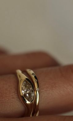 a woman's hand with a gold ring on it and a diamond in the middle