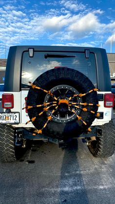 a truck parked in a parking lot with orange arrows on it's tire rims