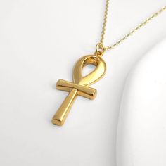 An elegant 24k gold plated ankh charm necklace. The perfect gift  for anyone who loves Ancient Egyptian mysteries.  The ankh represents the key of life and brings good fortune.  Every order comes in beautiful packaging with a free gift box included. All packaging, including gift boxes are eco friendly. SIZE: Choose from either 16, 18 or 20 inch gold plated chain and 2 inch extender (at no extra cost). MATERIALS: 24K gold plated brass, DELIVERY: All orders are despatched within 2 days. UK - FREE Gold Ankh Amulet Jewelry, Gold Ankh Jewelry For Gifts, Handmade Gold Ankh Necklace, Handmade Ankh Gold Necklace, Gold Ankh Necklace Gift, Gold Ankh Amulet Necklace, Gold Ankh Necklace For Gift, Gold Cross Amulet Necklace, Ankh-shaped Yellow Gold Necklace For Gift