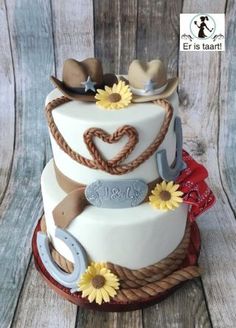 a three tiered cake decorated with cowboy hats, sunflowers and horseshoes