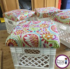 three white wicker stools with colorful fabric on them