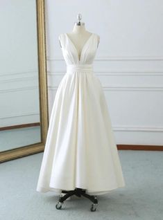 a white dress on a mannequin in front of a mirror