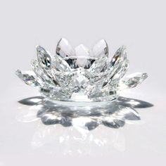 a large diamond ring sitting on top of a white surface with its reflection in the glass