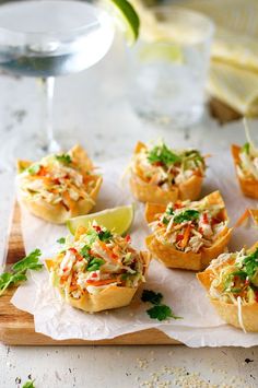 small appetizers on a cutting board with a glass of wine in the background