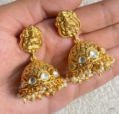 Luxurious Temple Jhumka earrings are a stunning example of South Indian jewelry, featuring intricate Kundan and Polki work. Plated in 22k gold for a regal finish, the earrings are adorned with delicate pearls for a timeless touch. The antique design evokes traditional elegance, perfect for special occasions. *𝐏𝐑𝐎𝐃𝐔𝐂𝐓 𝐃𝐄𝐓𝐀𝐈𝐋* * Material:  Brass  * Plating:  22K Antique Gold Plated *DIMENSIONS* * Weight 17 gm Each *𝐃𝐈𝐒𝐂𝐋𝐀𝐈𝐌𝐄𝐑* Product color may slightly vary due to photograp Jewelry Kundan, Polki Earrings, South Indian Jewelry, Kundan Earrings, India Jewelry, Jhumka Earrings, Antique Design, South India, Antique Earrings