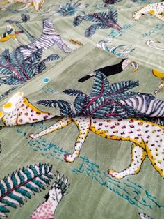 an animal themed bedspread with zebras and giraffes on it