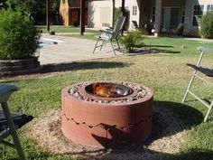 a fire pit sitting on top of a lush green field