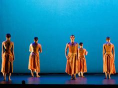 a group of people standing on top of a stage in front of a blue wall