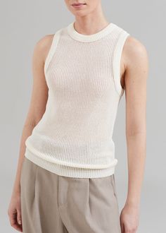 Color: Cream Midweight open rib knit with stretch Slim fit Sheen finish Crew neckline Sleeveless Ribbed knit trim Slip-on style Unlined 84% Rayon 16% Polyamide Dry Clean By Low Classic. Made in South Korea Classic Soft Knit Cream Top, Classic Cream Knit Top, Classic Sleeveless Ribbed Top, Classic Cream Sleeveless Top, Chic Cream Knit Tank Top, South Korea, Crew Neckline, Rib Knit, Sleeveless Top