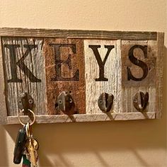 a wooden key holder with keys hanging from it's hooks and the word yes on it