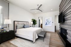 a bedroom with a bed, dresser and ceiling fan