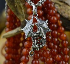 a dragon charm is attached to some red beads