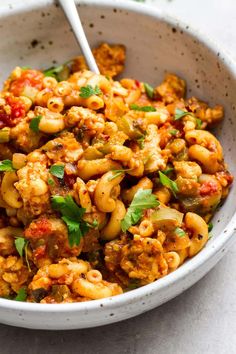 a white bowl filled with pasta and vegetables