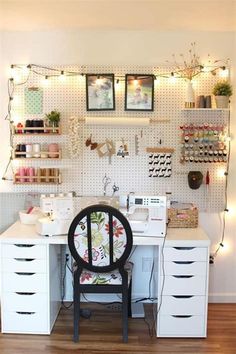 a sewing room with lots of crafting supplies on the wall and lights hanging from the ceiling