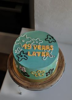 a cake that is sitting on top of a wooden stand with the words 19 years later