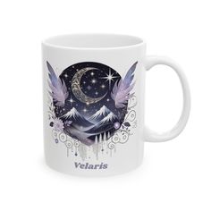 a white coffee mug with an image of the mountains and stars on it, in front of