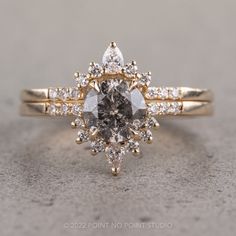 a yellow gold engagement ring with an oval cut diamond surrounded by smaller round brilliant diamonds