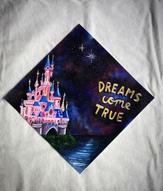 a graduation cap with the words dreams come true written in front of a castle at night