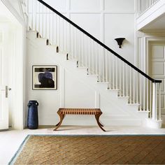 a wooden bench sitting under a stair case