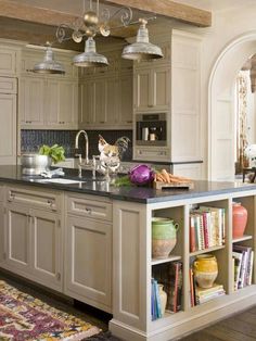 a large kitchen with an island in the middle and lots of cupboards on both sides