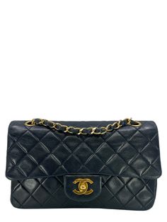 We  the ity of this Chanel Quilted Lambskin Small Classic Double Flap Bag crafted in supple dark navy blue diamond quilted lambskin leather and gold-tone hardware. This iconic bag features a chain link and leather shoulder strap that can be  long or doubled, an exterior rear pocket and a double front flap with signature  CC turn lock closure. Condition: Very Good. The exterior front and rear of the bag is overall clean with minor wear and scuffing. Faint creasing and indentations are present. Gentle rubbing has developed on the bottom edge corners and at the corners of the flap. The gold-tone hardware shines bright but has very minor tarnishing on the shoulder straps chain links and on the front turn-lock closure. The leather under the inside flap has scratches. The interior lining is clea Luxury Flap Bag With Detachable Handle And Double Flap, Luxury Double Flap Bag With Detachable Strap, Luxury Double Flap Evening Shoulder Bag, Luxury Double Flap Travel Flap Bag, Luxury Double Handle Flap Bag With Fold Over Clasp, Luxury Gold Double Flap Bag, Luxury Classic Double Flap Shoulder Bag, Chanel Flap Bag, Versace Bags