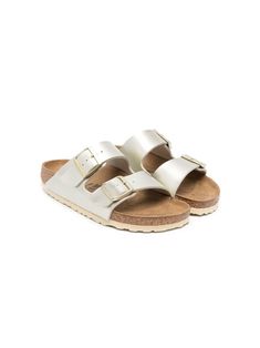 Arizona metallic sandals from Birkenstock Kids featuring gold-tone, leather, metallic finish, open toe, double-strap design, front buckle fastening and flat rubber sole. White Berken Stocks, Spring Gold Footbed Sandals With Buckle Closure, Gold Slide Footbed Sandals With Buckle, Gold Slide Footbed Sandals With Buckle Closure, Gold Buckle Footbed Sandals For The Beach, Gold Footbed Sandals With Buckle For Beach, Gold Buckle Closure Footbed Sandals For Beach, Gold Footbed Sandals With Buckle Closure For Beach, Casual Gold Slides With Buckle Closure