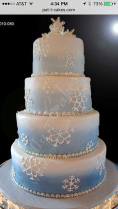 a blue and white wedding cake with snowflakes on it