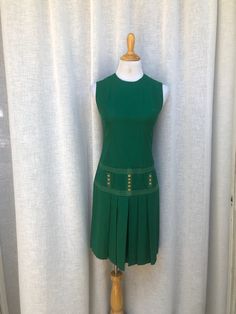 "Beautiful deep green cotton feel fabric dress with dropped waist, front buttoned pockets, pleated skirt and back zipper closure by Liberty Square. The dress is in a great vintage condition. Fits approximately size 4-6 US.  Measurements (flat): Shoulder to shoulder: 13.5\" Armpit to armpit : 16\" waist: 30\" hips: 34\" Overall length: 37\"" Green Fitted A-line Pleated Dress, Green Pleated Knee-length Mini Dress, Classic Sleeveless Pleated Work Dress, Classic Sleeveless Pleated Dress For Work, Sleeveless Pleated Dress With Box Pleat For Summer, Fitted Sleeveless Pleated Dress With Box Pleat, Sleeveless Box Pleat Pleated Dress For Summer, Green A-line Dress With Pleated Skirt, Fitted Green Dress With Pleated Waist