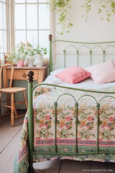 a bed with pink and green pillows on it's headboard in a bedroom