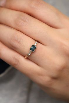 a woman's hand with a ring on it and a blue stone in the middle