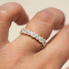 a woman's hand with a diamond ring on top of her finger, showing the band