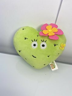 a green stuffed heart with a flower on it