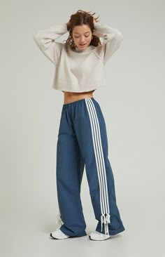 Step into athleisure vibes with the PacSun Wide Leg Track Pants. These trendy track pants combine comfort and style with a wide-leg silhouette, stripes down the leg, and ties at the ankles, offering a versatile and laid-back addition to your wardrobe, perfect for casual outings or cozy days at home.11.5" rise31.5" inseam23" leg openingHigh-riseElastic waistbandStripes down the legsTie detail at the ankleSide hand pocketsWide leg openingRelaxed fitRoomy through the hip and thigh62% cotton, 38% ny Wide Leg Striped Pants, Wide Leg Workout Pants, Nike Blue Pants, Popular Pants For Women, Casual Bottom Wear For Women, Athletic Streetwear Women, Styling Track Pants Women, Gym Outfits For Women Sweatpants, Japan Streetwear Women