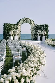 an outdoor ceremony setup with white flowers and chairs