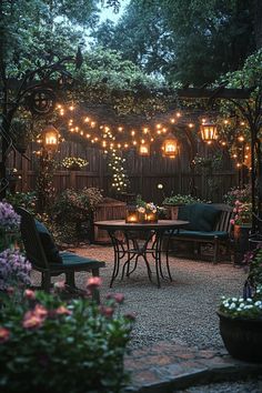 an outdoor dining area with lights strung over the table and chairs, surrounded by potted plants