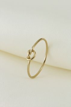 Tarnish Resistant 14k Gold Filled Love Knot Stacking Ring. This Gold Love Knot ring is Perfect for Stacking with your other Rings Band Thickness : 1mm Sizes Available (US Size) 1) 5 2) 6 3) 7 4) 8 5) 9 What is 14K Gold Filled? ''14K Gold filled" is a USA industry standard that legally requires 1/20th, or 5% pure gold by weight. It's a strictly regulated process that involves pressure bonding multiple layers of solid 14k gold with extreme heat over a core of high-quality jeweler's brass resulting Love Knot Ring, Stack Ring, Knot Ring, Love Knot, Stackable Ring, Diy Schmuck, Pure Gold, Stacking Ring, Gold Filled Jewelry