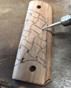 a piece of wood with holes in it being worked on by a person using a drill