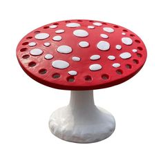 a red and white mushroom shaped table with dots on it