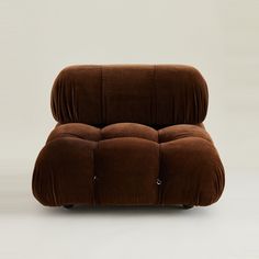 a brown reclining chair sitting on top of a white floor