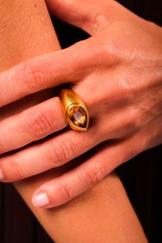 Center Stone: Pear Shape Brown Citrine Weight: Approximately 4.3 CaratMetal: 18K Yellow GoldEra: VintageCirca: 1980sHallmarks: Purity MarksSize: 4 3/4 and can be resizedGram weight: 19.07 This striking vintage ring from the 1980s features a beautifully faceted 4.3-carat pear shape brown citrine set in a bold bezel of 18K yellow gold. The warm hue of the citrine is perfectly complemented by the rich gold setting, creating an eye-catching piece that exudes vintage charm. Weighing 19.07 grams and marked with purity hallmarks, this ring is a unique statement of elegance and style. Gold Pear-shaped Rings With Bezel Setting, Pear-shaped Gold Rings With Bezel Setting, Gold Pear-shaped Topaz Gemstone Ring, Formal Yellow Gold Topaz Teardrop Ring, Formal Pear-shaped Topaz Ring, Luxury Pear-shaped Yellow Gold Rings, Formal Pear-shaped Citrine Ring, Gold Teardrop Topaz Ring For Formal Occasions, Classic Pear-shaped Topaz Ring For Formal Occasions