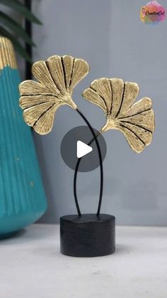 a gold leaf sculpture sitting on top of a table